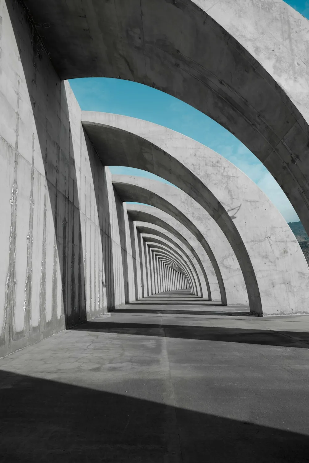 Repeating concrete arches beneath a blue sky